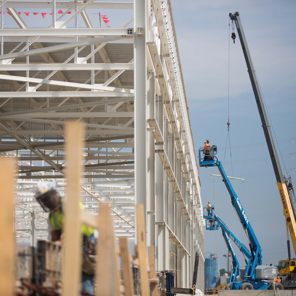 Workers build and inspect the steel structure of the GM Manufacturing Body Shop.