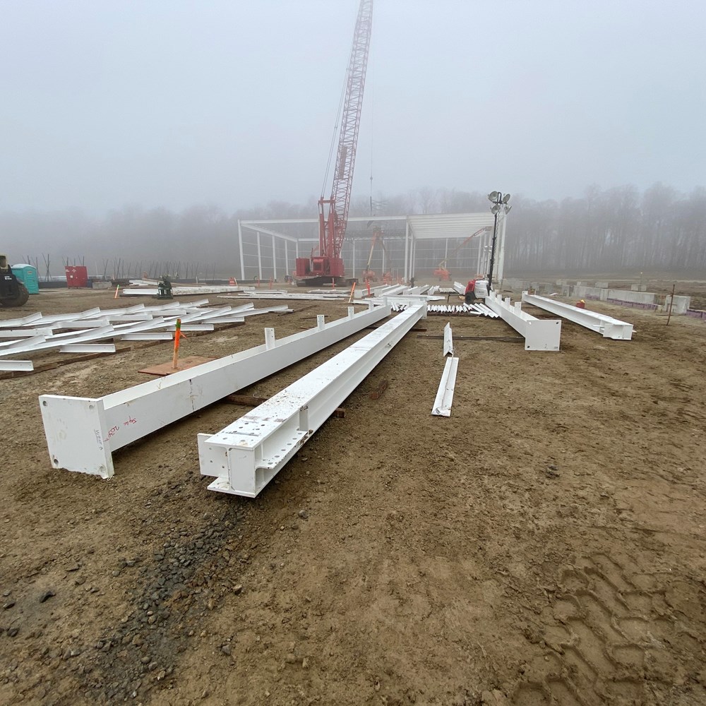 White steel rests in dirt at the Truck Diesel Engine plant job site.